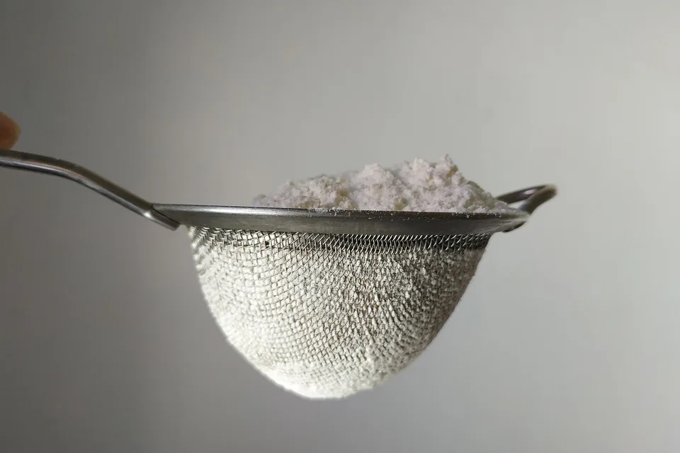 Мука просеивается через кухонное сито
